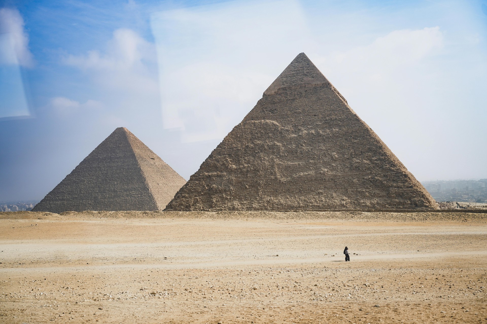 Decorated camels resting on the sand in front of the Khafre and Menkaure pyramids at Giza